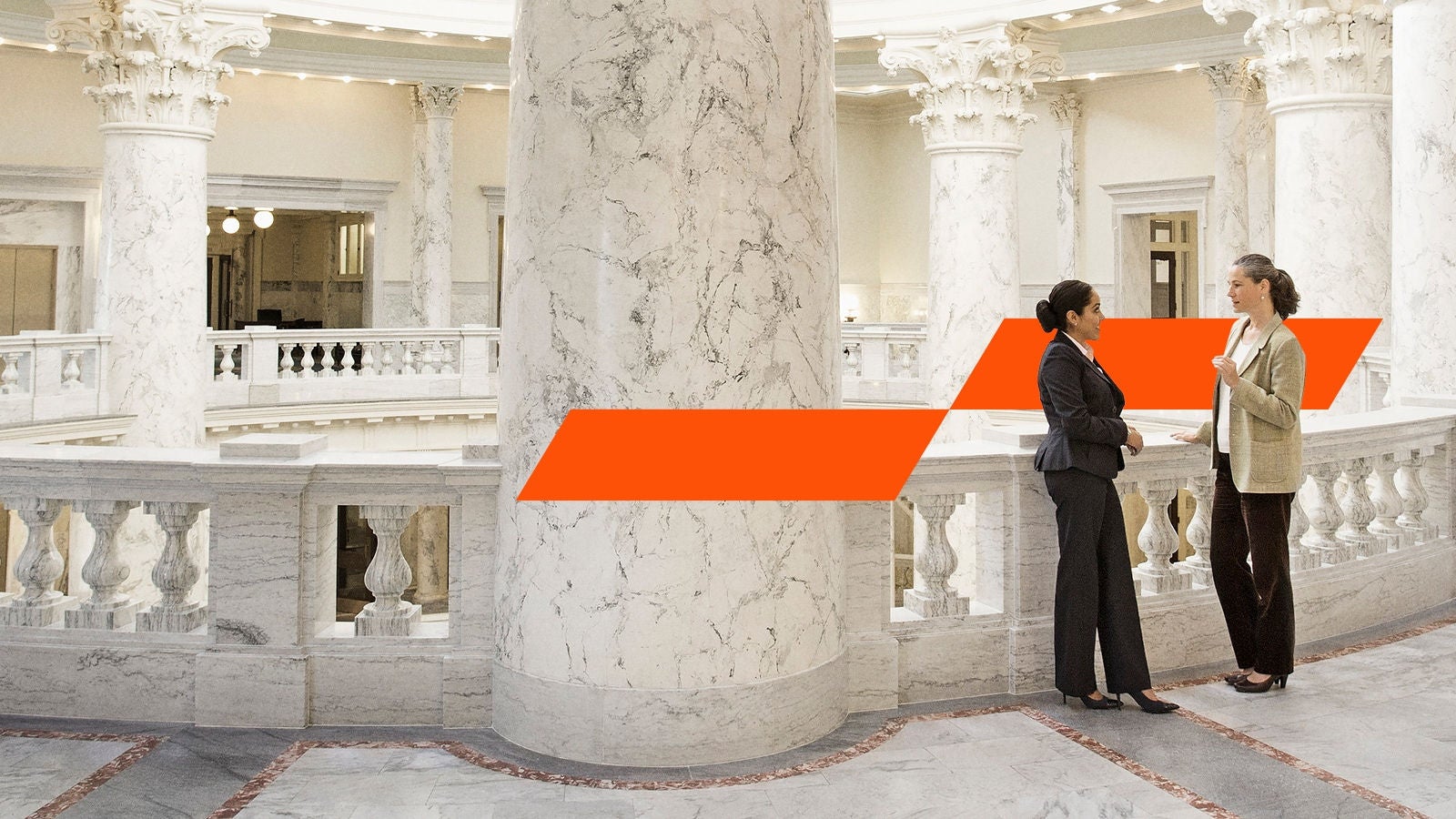 Two women standing in marble building