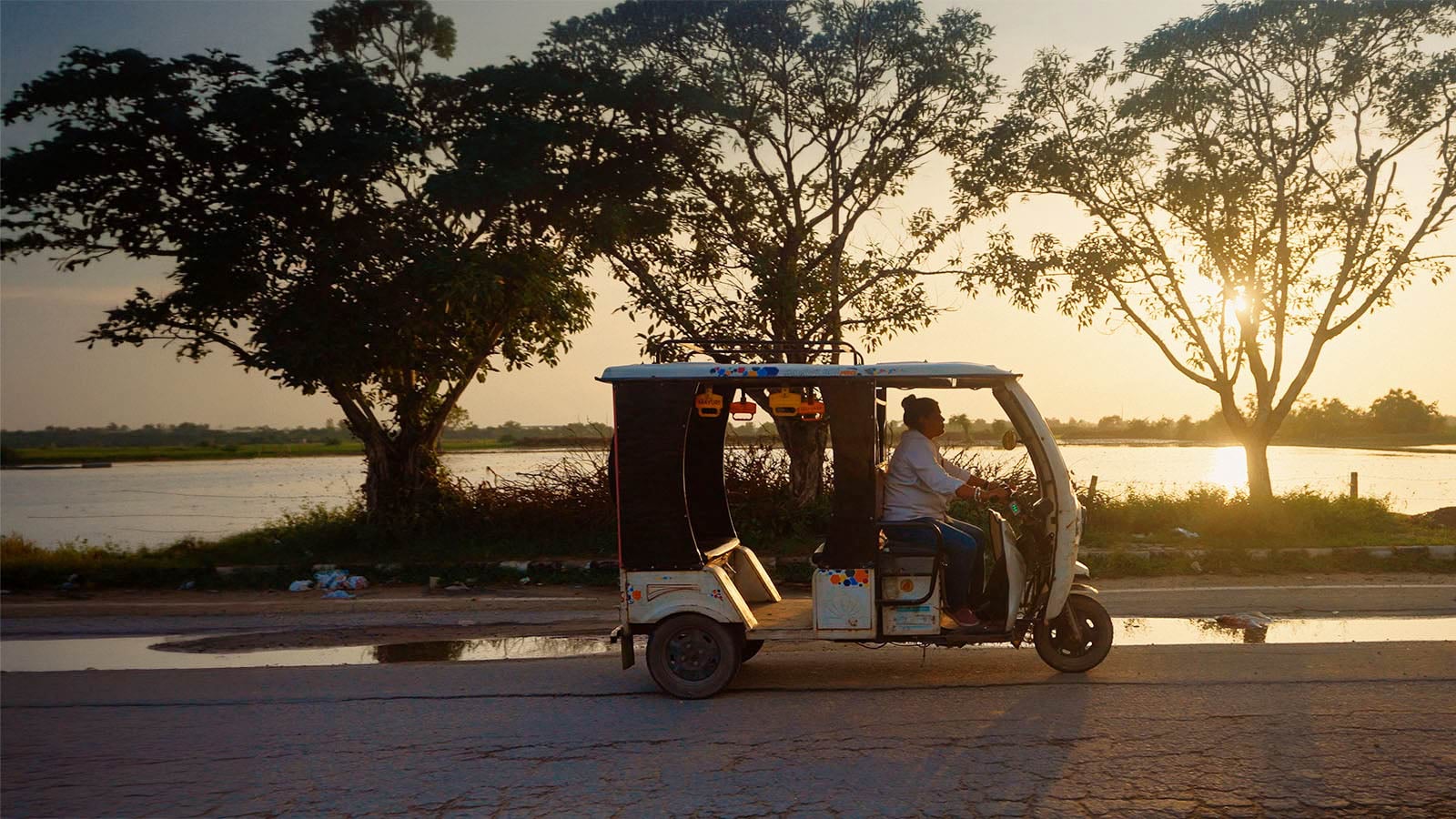 A rikshaw driving on the road at sunset