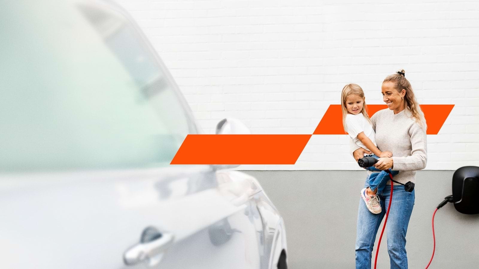 Mother and child standing next to a charging EV