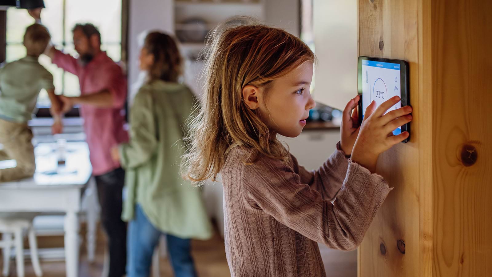 A girl interacting with a tablet on the wall